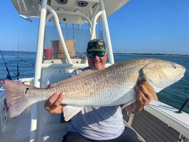 Angler proudly holding a very large redfish