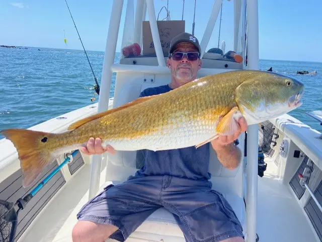 Angler seated aboard the Pathfinder with a golden redfish
